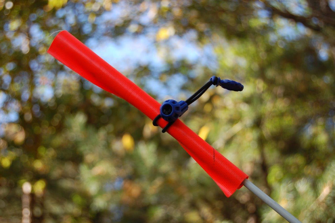 Furled flag lashed to pole on military jeep